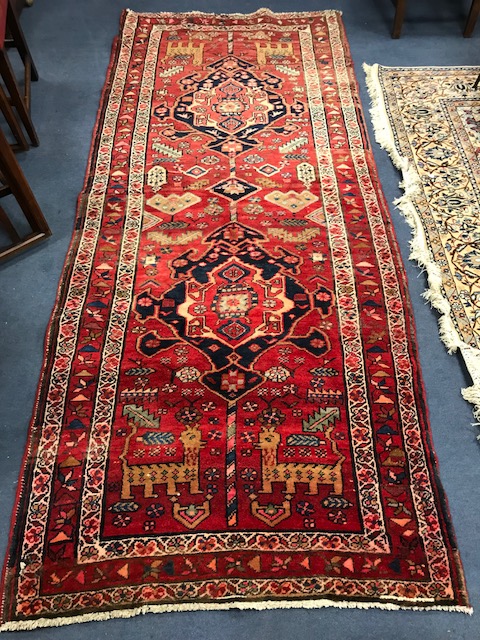 A Persian red ground hall carpet 260 x 105cm